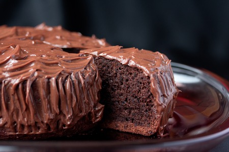 Chocolate Mud Cake on red serve dish on black backgroundの写真素材