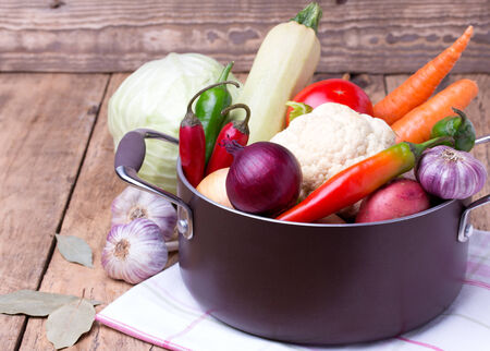 Close up of various colorful raw vegetables in pan on wooden backgroundの写真素材