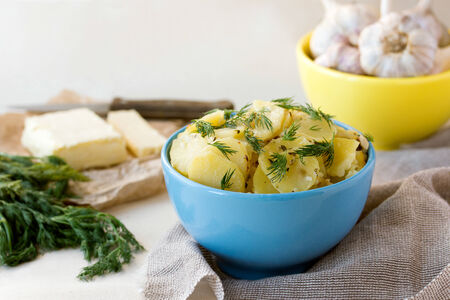Boiled sliced potatoes with fresh dill, butter and garlicの写真素材