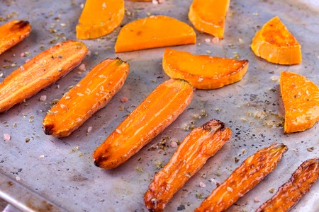 roasted pumpkin and carrot on well used oven baking trayの写真素材