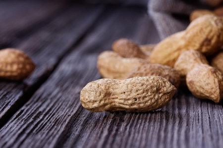 peanuts in a miniature burlap bag on wooden surfaceの写真素材