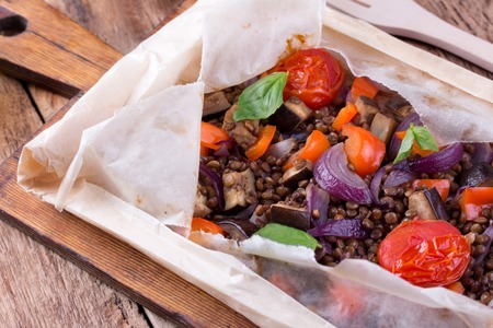 Baked lentils with tomato, eggplant and red onion, cooked in baking paper.の写真素材
