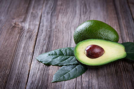 avocado with leaves on a dark wood background. Rustic.の写真素材
