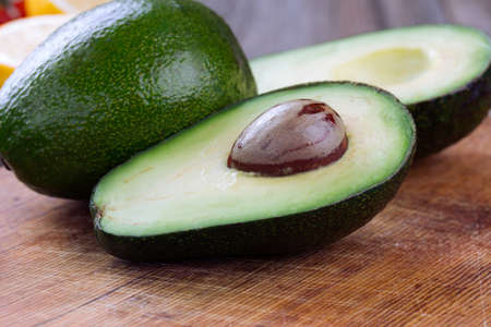 avocado with leaves on a dark wood background. Rustic.の写真素材