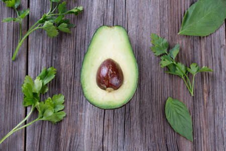 Sliced avocado with mint leaves on a dark wood background.の写真素材