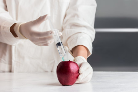 Scientist doctor injecting apple with syringe. Genetically modified fruit. GM food modification.の写真素材
