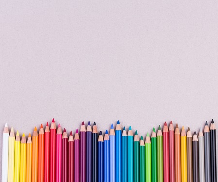 Multicolored pencils on beige pastel paper coarse grain grunge textureの写真素材