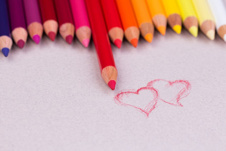 Multicolored pencils on beige pastel paper coarse grain grunge texture.の写真素材