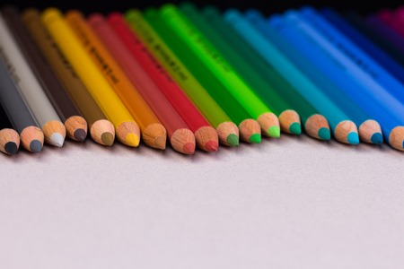 Multicolored pencils on beige pastel paper coarse grain grunge texture.の写真素材