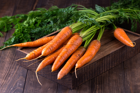 fresh carrots bunch on rustic wooden backgroundの写真素材