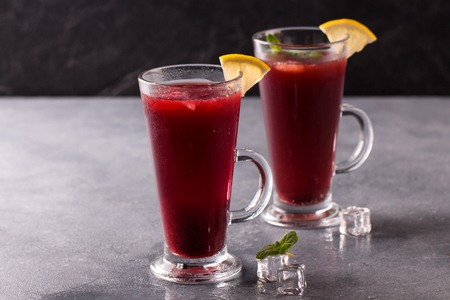 refreshing fruit punch beverage with ice in glass on stone backgroundの写真素材
