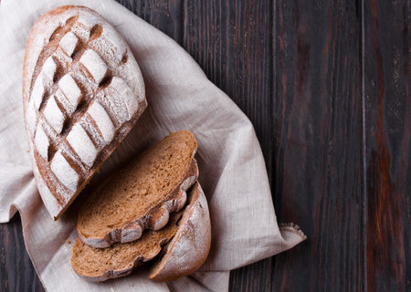 Freshly baked traditional bread on wooden table. Low key. Copy space