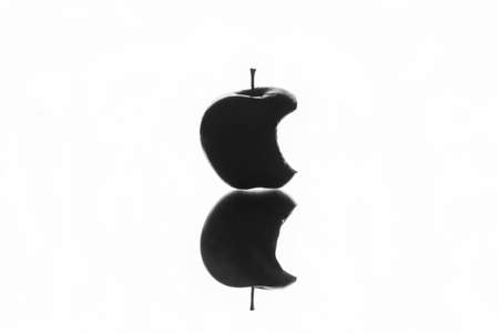 Bitten Apple Black Silhouette with reflection. White background.の写真素材