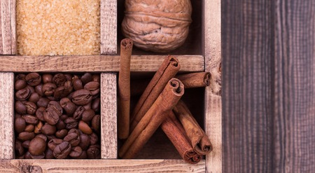Christmas decoration. Gift box filled with christmas spices and nuts like cinnamon sticks, anise , nutmeg , brown sugar, hazelnut, coffee beans and walnutの写真素材