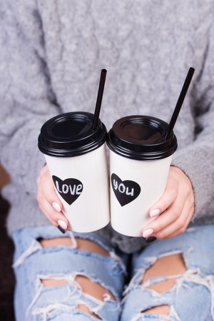 Couple in love holding hands with coffee.の写真素材