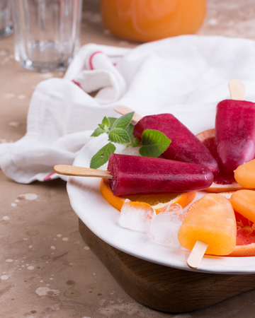 Pink and orange popsicle on grey stone background.の写真素材