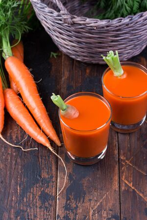 Fresh squeezed carrot juice on woodenの写真素材