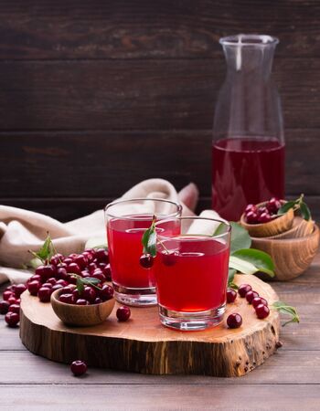 Glass of cherry juice on wooden tableの写真素材