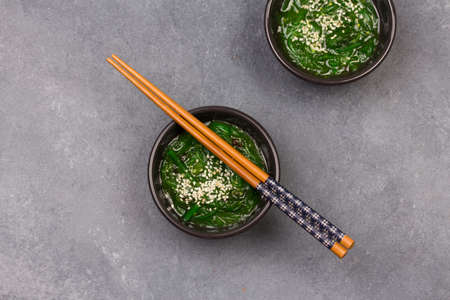 Tasty appetizing seaweed salad on dark plate on grey background.の写真素材