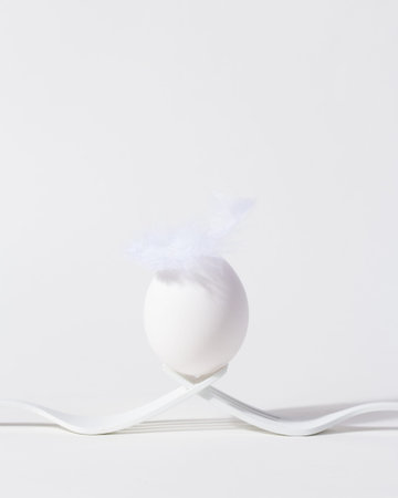 Minimal white Easter egg on bright background.