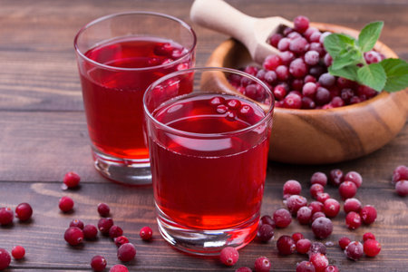 Organic cranberry juice in glasses with berries on wooden backgroundの写真素材