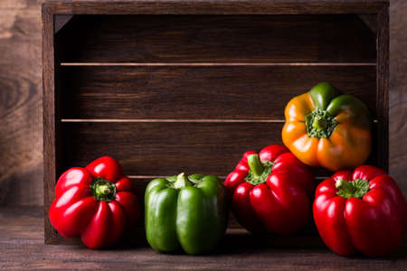 Fresh organic bell peppers on a wooden boardの写真素材