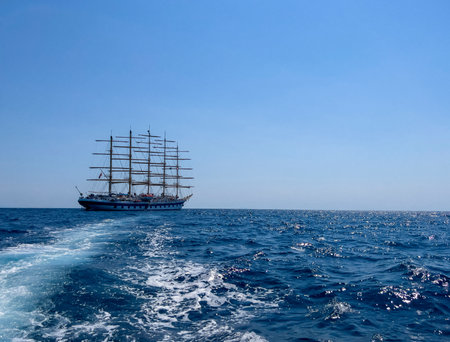 Sailing ship in the open sea on a background of blue skyの写真素材
