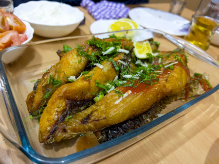 Fried mackerel with lemon and herbs on a wooden tableの写真素材