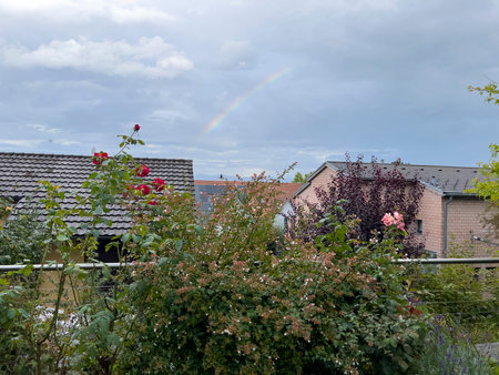 Rainbow over the roofs of houses in the village in summer.の写真素材