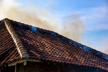 Smoke coming out of the roof of a burning house