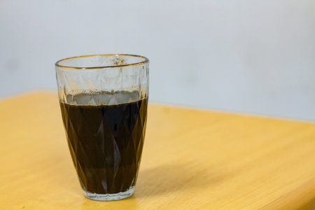 A cup of coffee sitting on a brown table