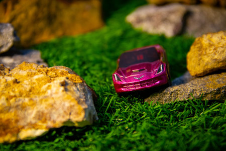 Toy car on rocks background with orange glow