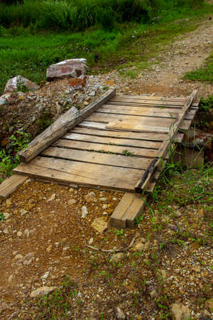 A bridge made of wooden planks that sits on the pathの写真素材