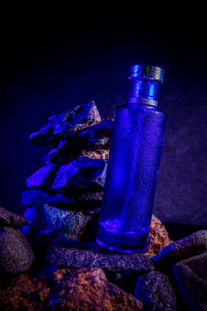 Glass bottle with rock background from the riverの写真素材
