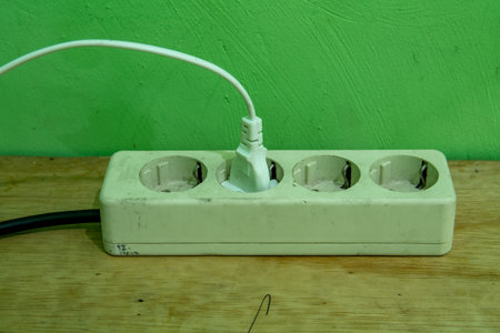 The white electrical socket on the wooden table