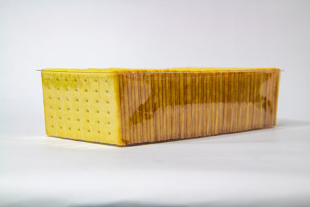 Biscuits neatly arranged in a plastic box on a white backgroundの写真素材