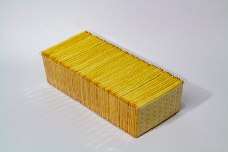 Biscuits neatly arranged in a plastic box on a white backgroundの写真素材