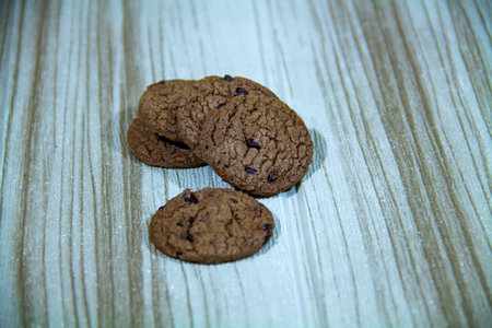 Pile of brown cookies against a wooden wall backgroundの写真素材