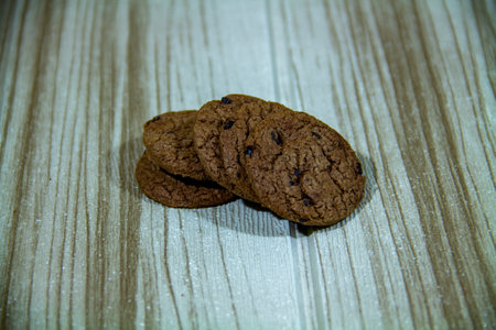 Pile of brown cookies against a wooden wall backgroundの写真素材