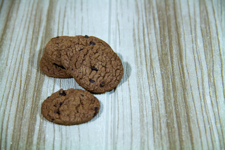 Pile of brown cookies against a wooden wall backgroundの写真素材
