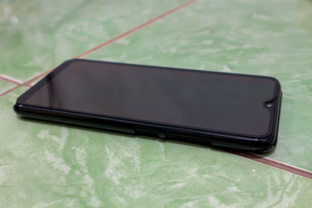 smartphone with black screen on the green tile floor, stock photoの写真素材