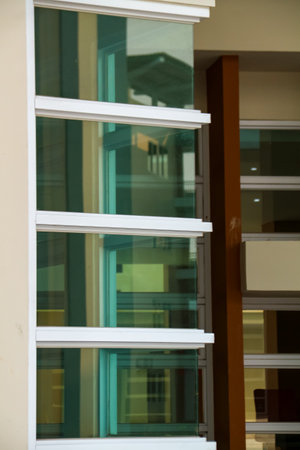 Detail of a window in a modern office building with green glassの写真素材
