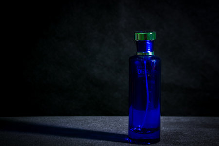 Blue glass perfume bottle on black backgroundの写真素材