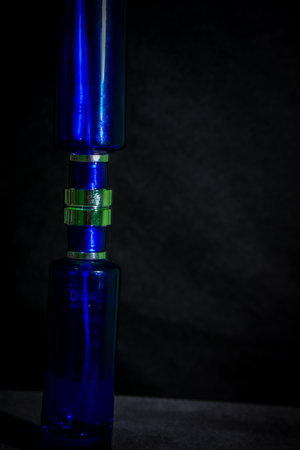 Blue glass perfume bottle on black backgroundの写真素材