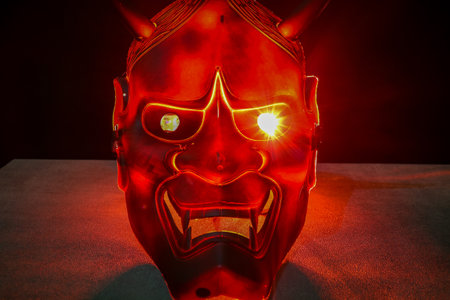 Black devil mask with bright colored neon lights backgroundの写真素材