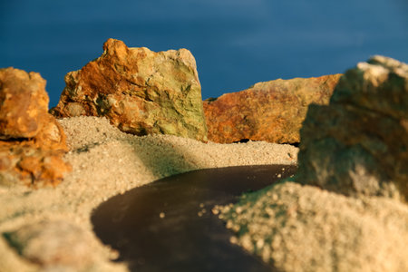 The background theme is rocks and sand with a black road with bright light like the afternoon sunの写真素材