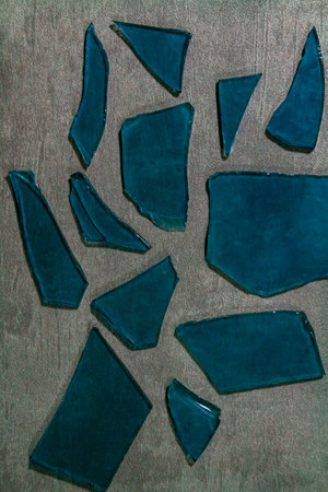 Pieces of blue glass on a gray background. Collage.の写真素材