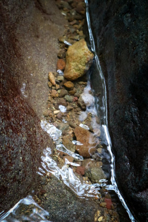 Streams of water flowing through the rocks, close-up.の写真素材
