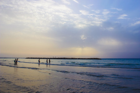 People enjoying a beach sunset strollの素材