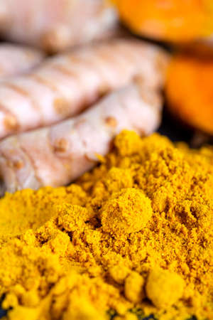 Food and drink, diet nutrition, health care concept. Raw organic orange turmeric root and powder, curcuma longa on a grunge cooking table. Indian oriental low cholesterol spicesの写真素材